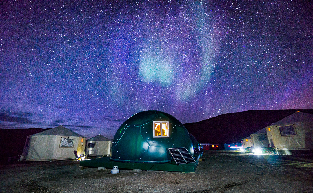 Guy Therriault peers out at the northern lights from his sleeping quarters, Torngat Mountains Base Camp and Research Station, Northern Labrador Mountains, (Newfoundland and Labrador), Canada