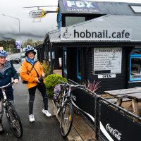 Mike Browne and Colin Monteath on bikes outside Fox Glacier tours, Fox Glacier village, Tai Poutini National Park, New Zealand