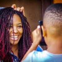 The son of our hosts at Secrets Guesthouse in Entebbe snaps a pic of his sister's hair being braided by her mom.