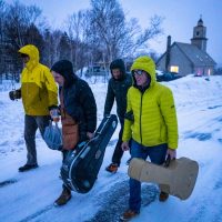 Musicians leave Highlands Hostel on their way to a kitchen party along the "Abbey Road" of Cape North, Cape Breton Island, Nova Scotia adventure ski shoot for Ski Canada magazine.