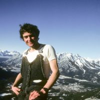 Pat Morrow portrait, in homemade salopettes, atop Mt Rundle, Banff behind, in January of 1981, training for Mt Aconcagua.